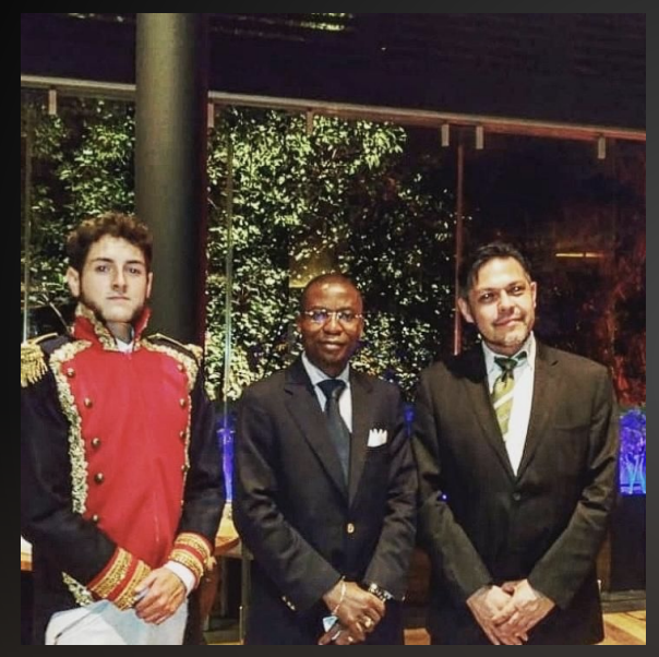 Encuentro formal entre comitivas diplomáticas internacionales junto a personaje histórico caracterizado